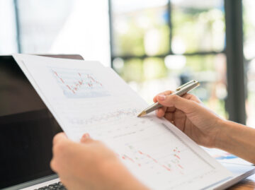 Business woman hand with Financial charts and laptop on the tabl Versicherungsmakler Essen