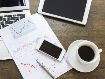 Laptop, tablet , smartphone and coffee cup with financial docume Versicherungsmakler Essen